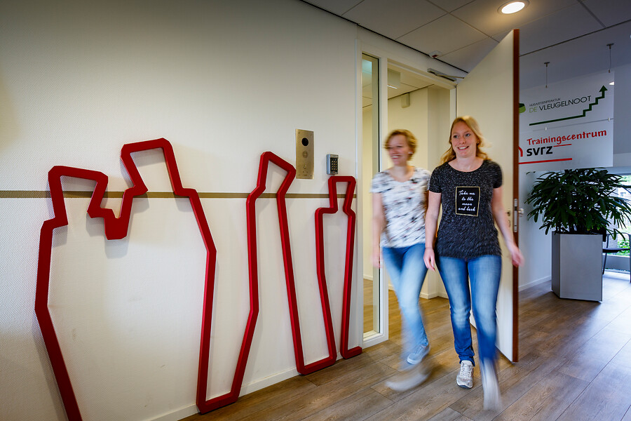 Twee medewerkers lopen in de gang van het Trainingscentrum van SVRZ