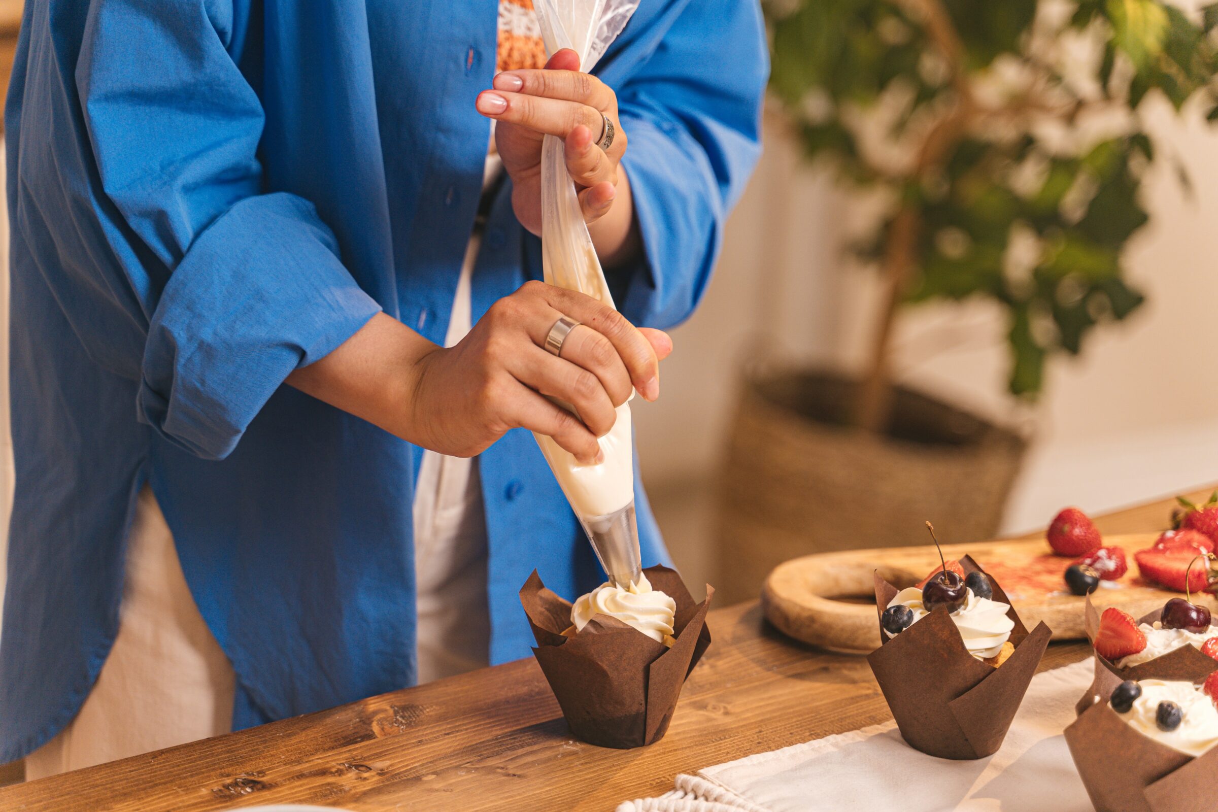 mevrouw versiert cupcake met spuit