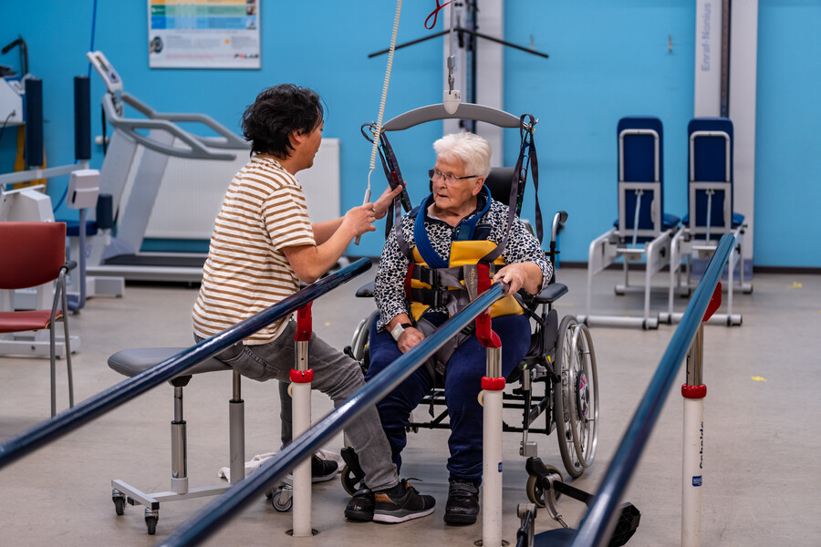 Een fysiotherapeut behandelt een cliënte in de loopbrug
