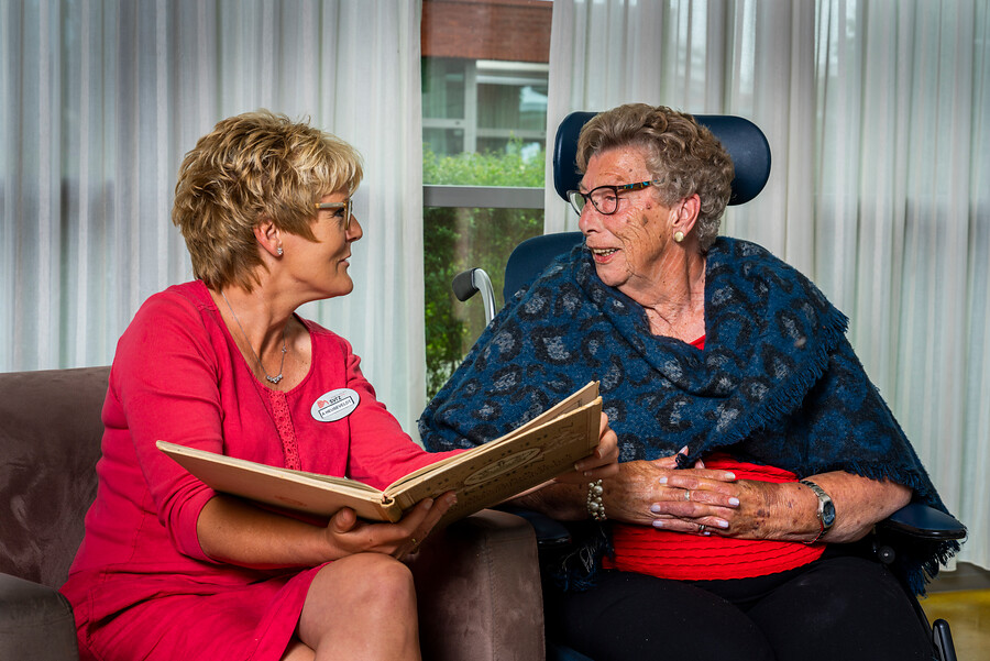 Medewerker leest boek voor aan cliënt