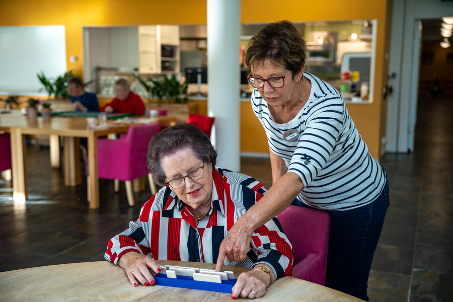 Medewerker helpt cliënt bij rummikub