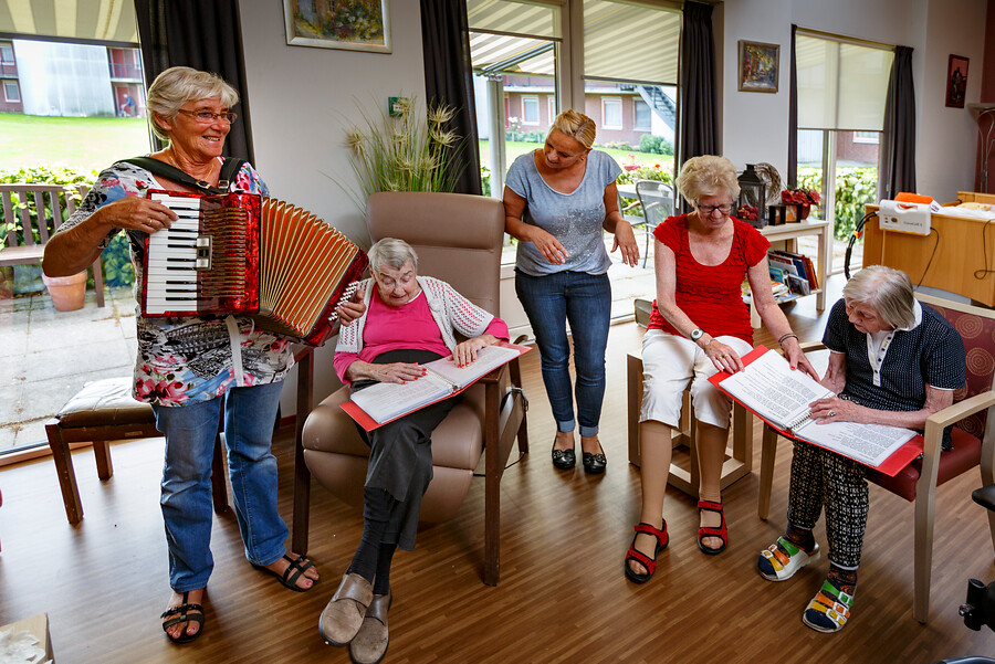 Medewerkers en cliënten maken samen muziek en zingen