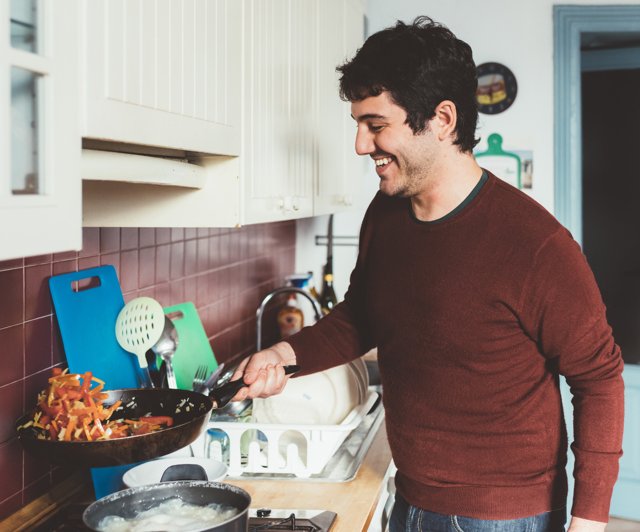 Man achter het fornuis aan het koken.