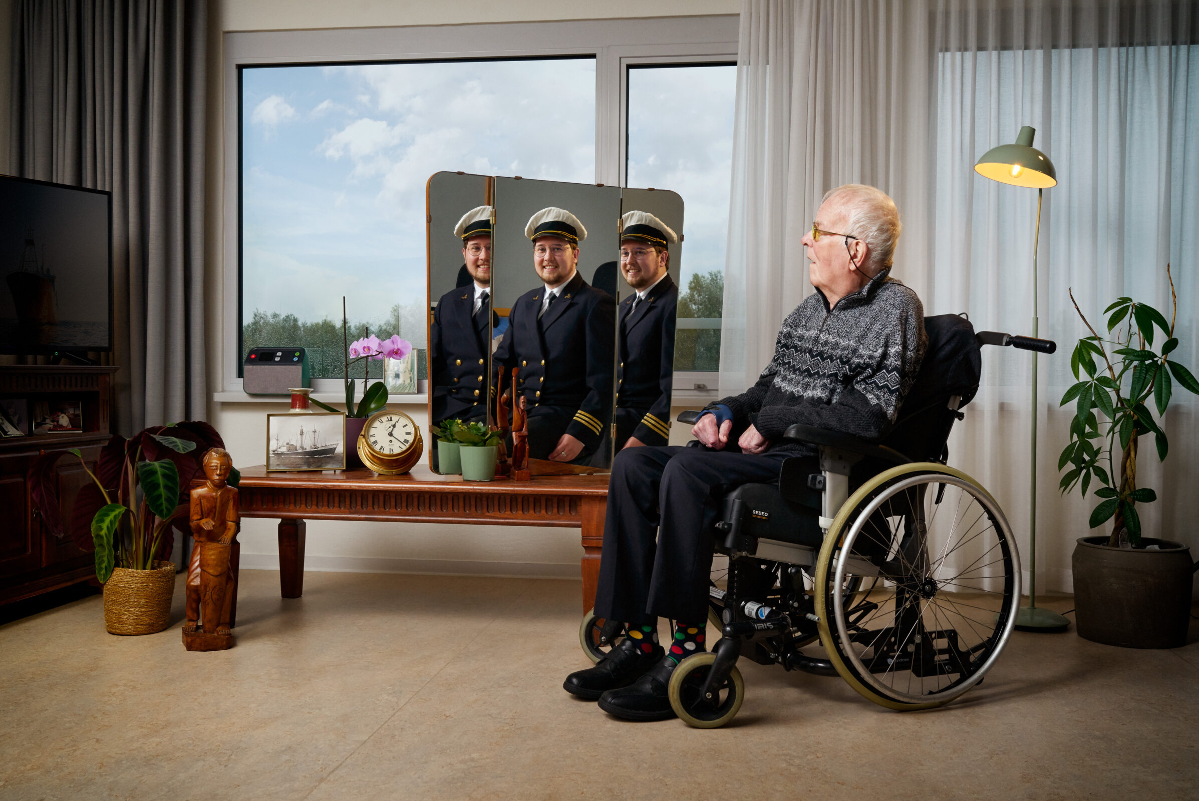 Man in rolstoel kijkt naar een jongere versie van zichzelf in een spiegel