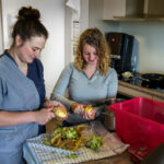 Twee medewerkers schillen aardappelen