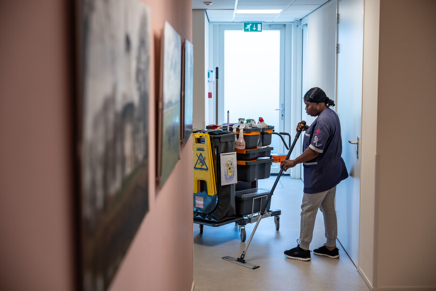 Dame achter schoonmaak kar maakt vloer schoon