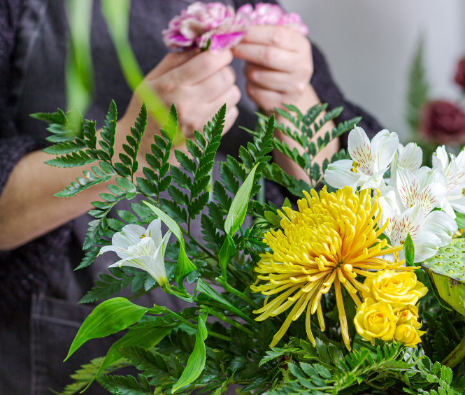 Vrouw schikt een boeket bloemen