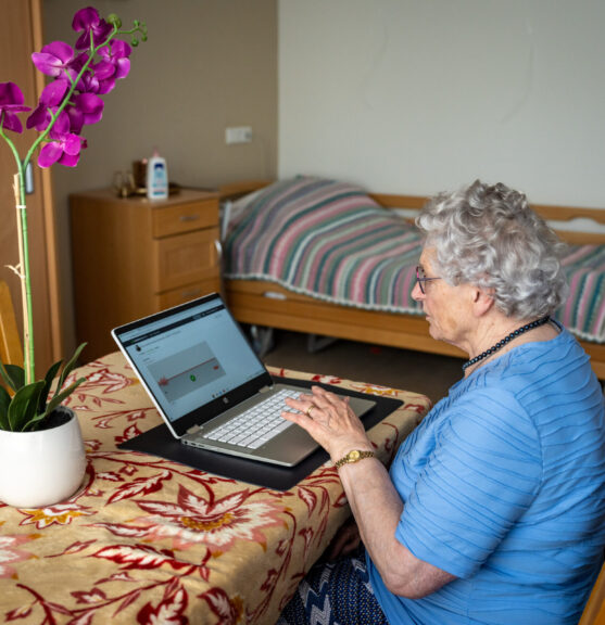 Vrouw aan tafel aan het werk op een laptop