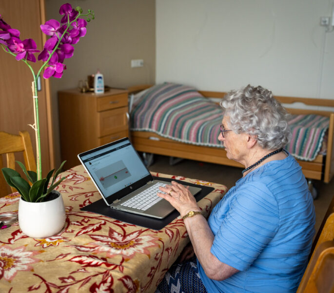 Vrouw aan tafel aan het werk op een laptop