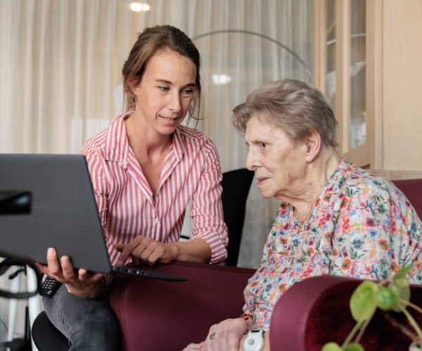 Medewerker geeft een cliënt uitleg met behulp van een laptop.