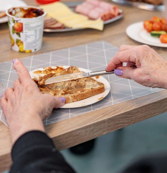 Mevrouw smeert boterham met pindakaas