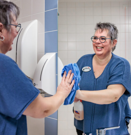 Medewerker maakt de badkamer schoon