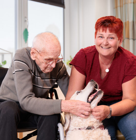 Dame en heer aaien een witte hond